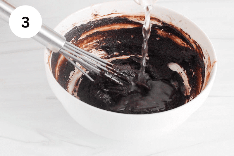 Water pouring in a thick chocolate sauce in a bowl.