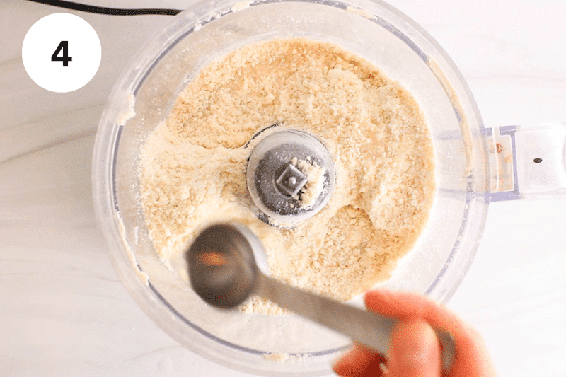 Adding water to a food processor with a flour mixture.