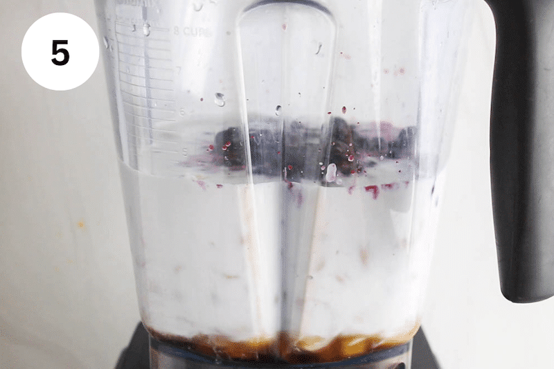 Blueberries with coconut milk in a blender.