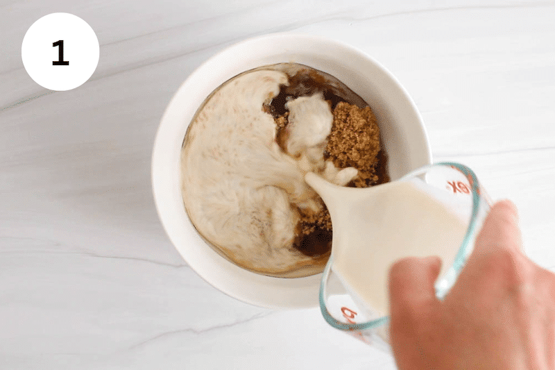 Milk pouring in a small bowl with melted coconut oil, sugar and vanilla.
