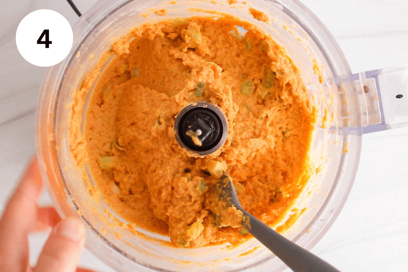 A spatula mixing in a food processor.
