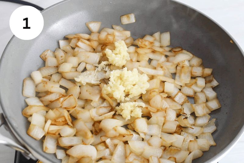 Onion and garlic cooking in a small pan.