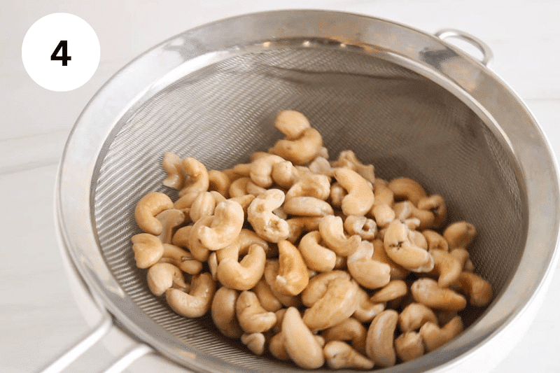 Draining cashews in a colander.