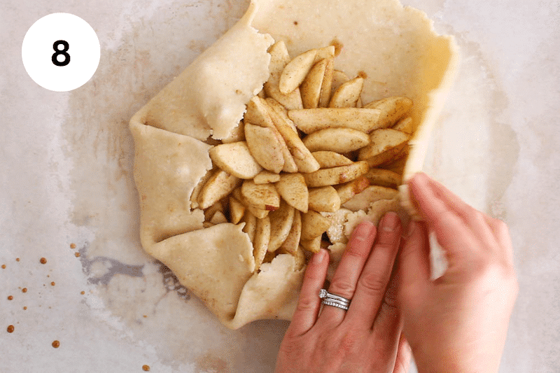 Folding the dough over the apple mixture.