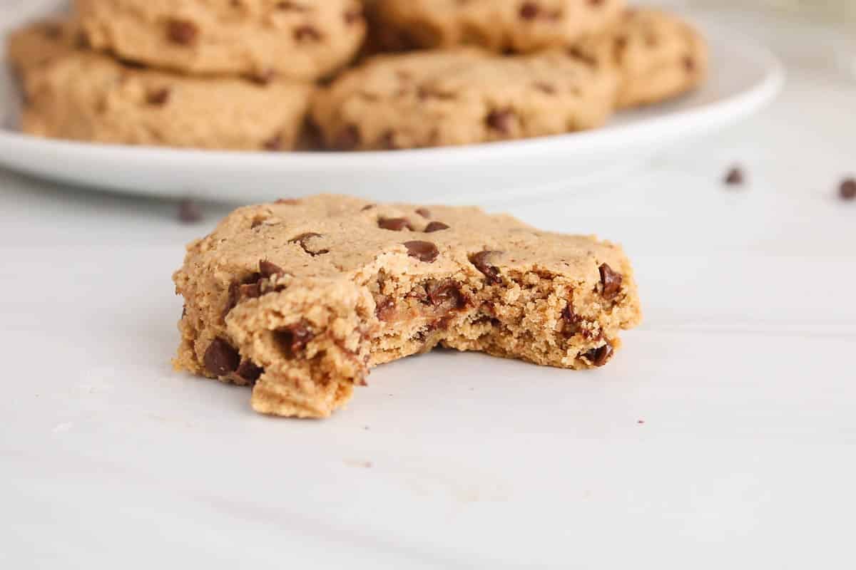 Vegan oat flour cookie with a bite taken off showing the chewy interior.