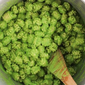 A large pot filled with short noodles tossed in a creamy pea pasta sauce.