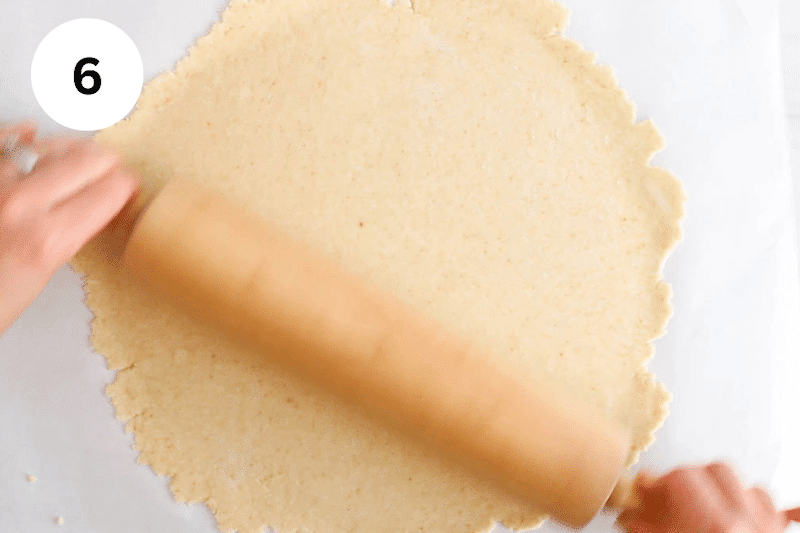 Rolling the galette dough into a large disc.