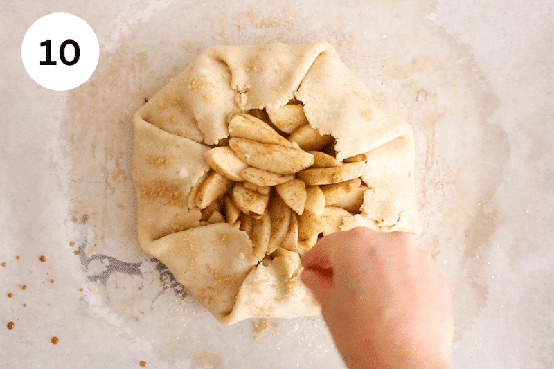 Sprinkling sugar over a vegan apple galette.