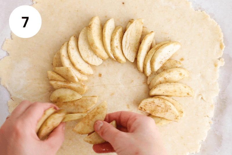 Adding cinnamon apple over the galette dough.