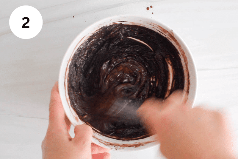 Gritty chocolate mix being mixed with a whisk.