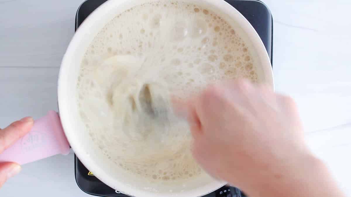 Whisk stirring in a sauce pan the milky mixture.