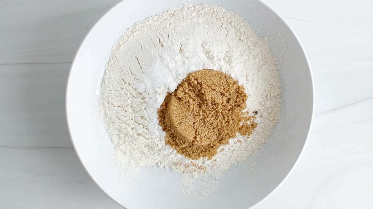 Large white bowl with flour, sugar, baking powder, baking soda and salt.