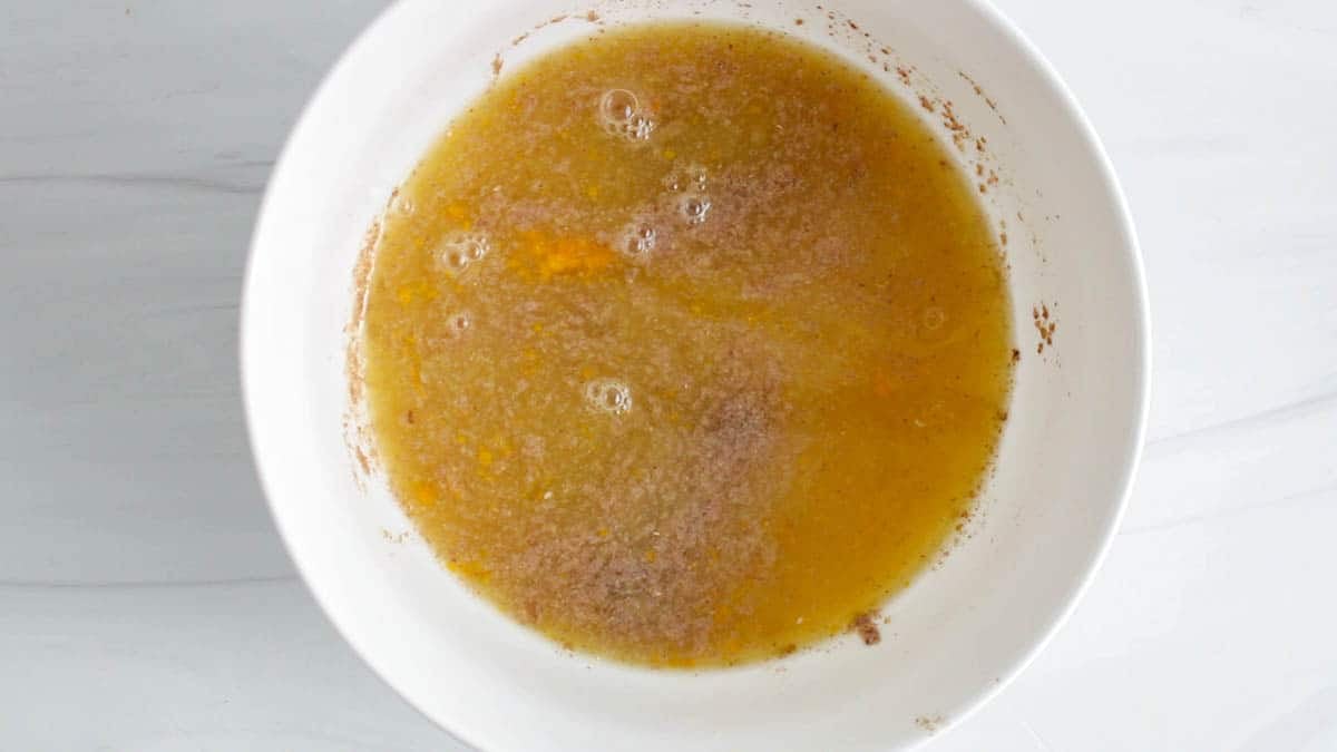 Medium white bowl with flax egg, orange juice and coconut oil.