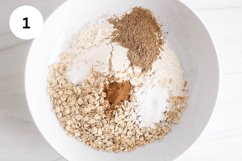Rolled oats, flour, baking powder and cinnamon in a large bowl.