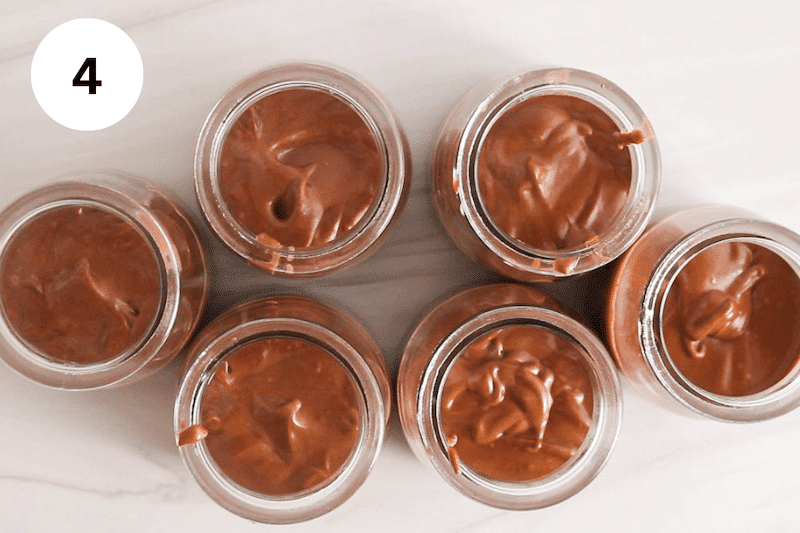 A few jars of chocolate cashew mousse on a counter.