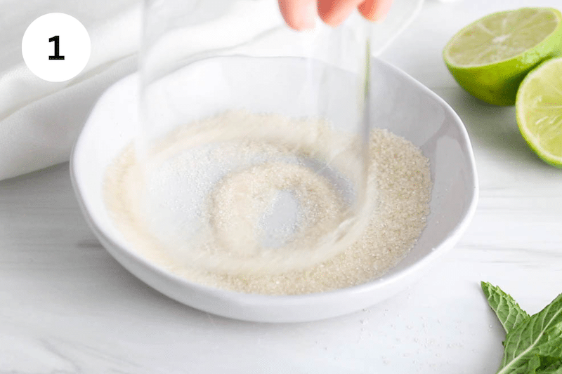 A glass flipped in a plate with sugar.