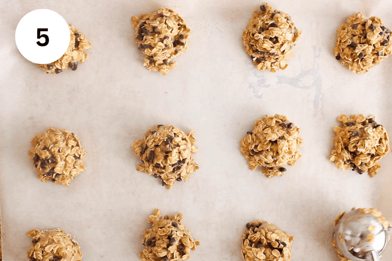 Baking sheet with an ice cream scoop distributing cookie dough.