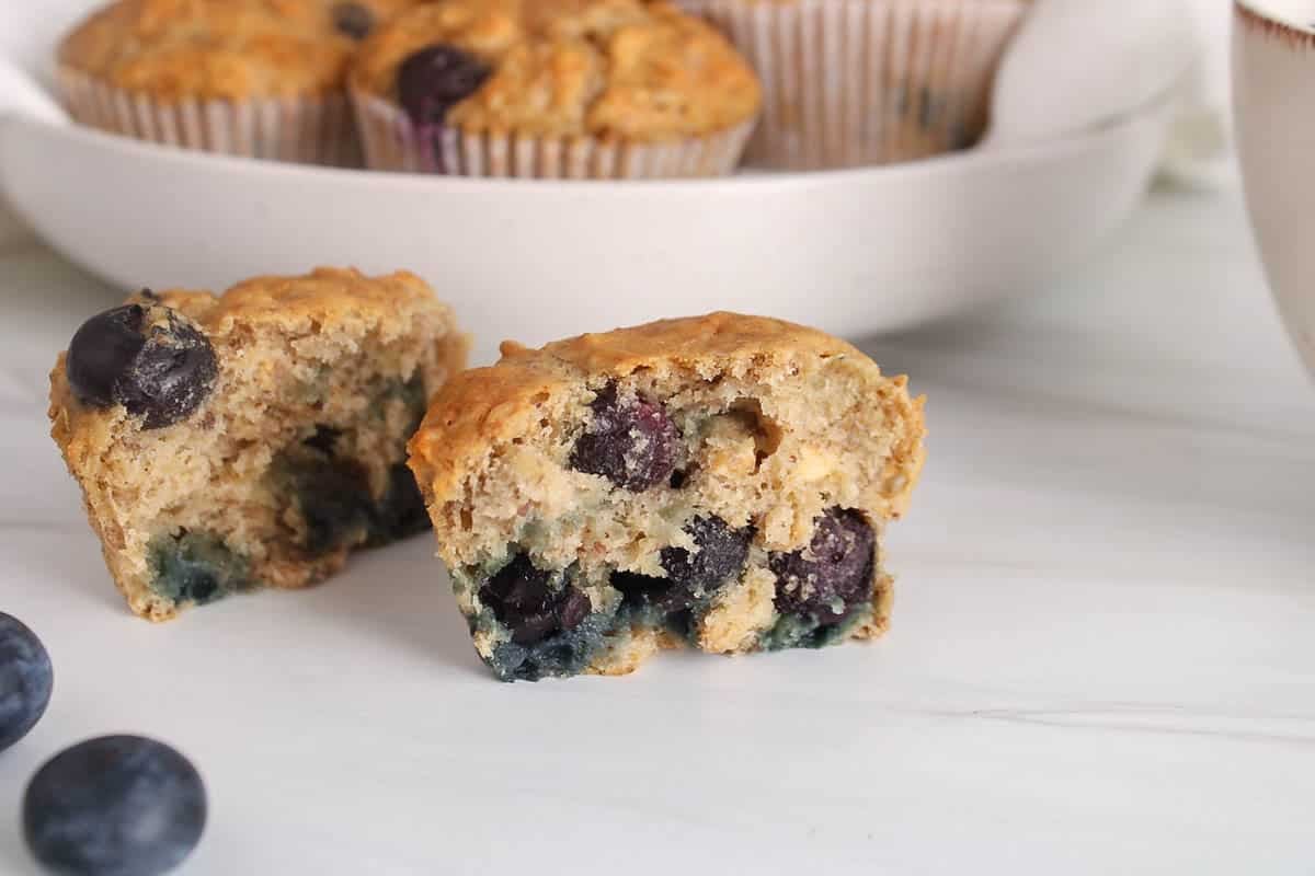 Banana blueberry oatmeal muffins sliced in half and placed on a table.