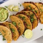 A few crispy baked tacos made with black beans and a side of guacamole.