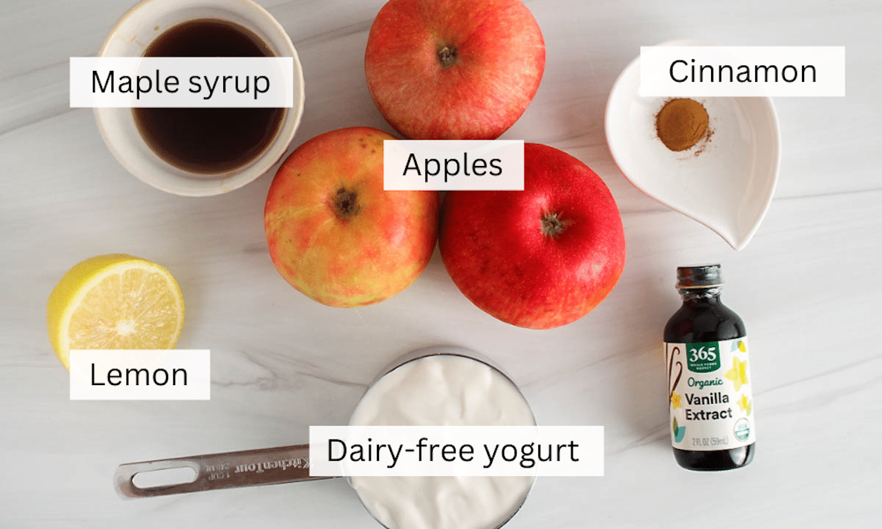 Ingredients to make apple popsicles on a white tables.