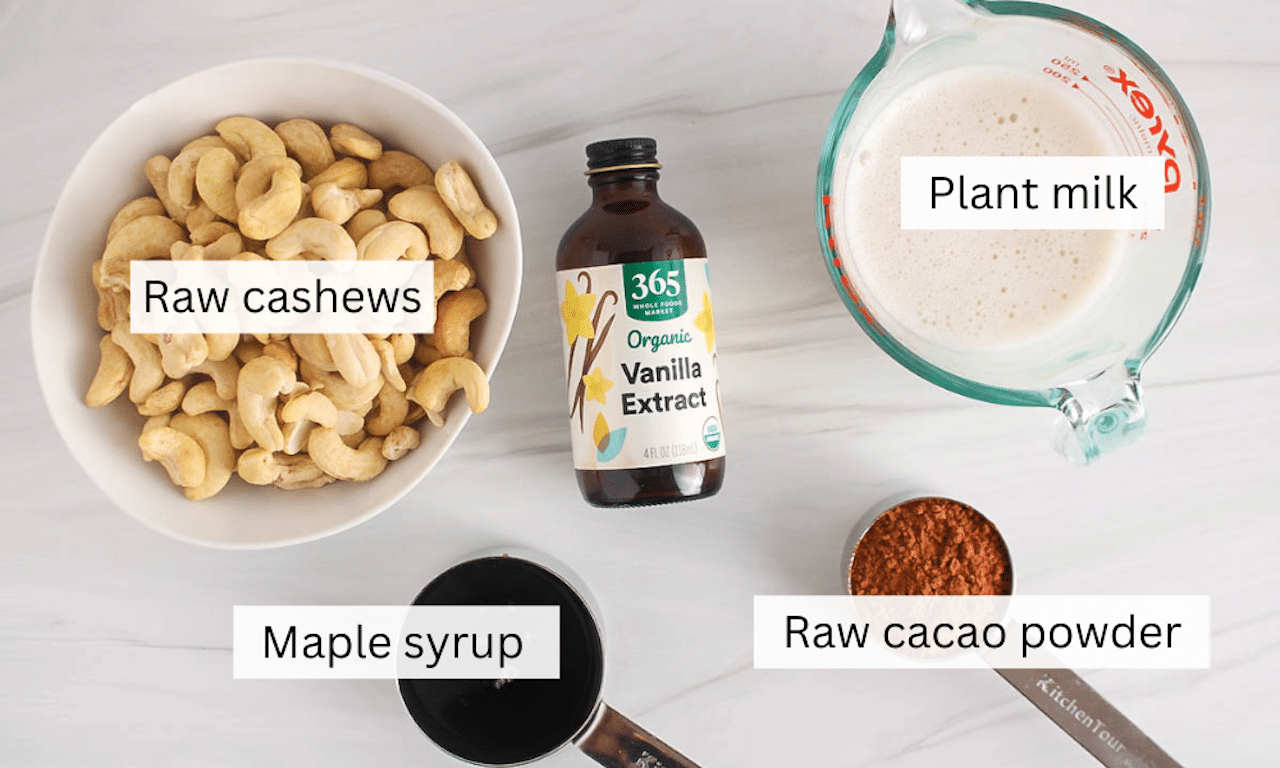 Ingredients needed to make a vegan chocolate cashew mousse placed on a white counter.