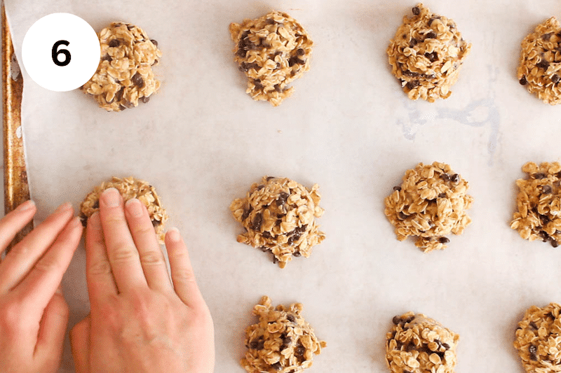 Hands pressing on cookie dough to shape them.
