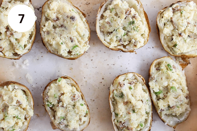 Filled potatoes placed on a baking sheet.