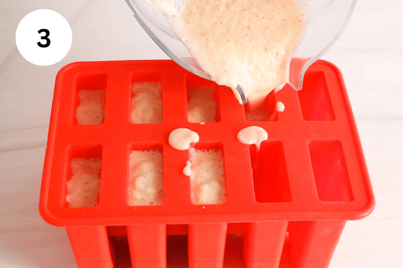 Pouring a popsicle mixture in a popsicle mold.