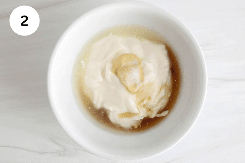 A small white bowl with vegan mayo and other dressing ingredients.