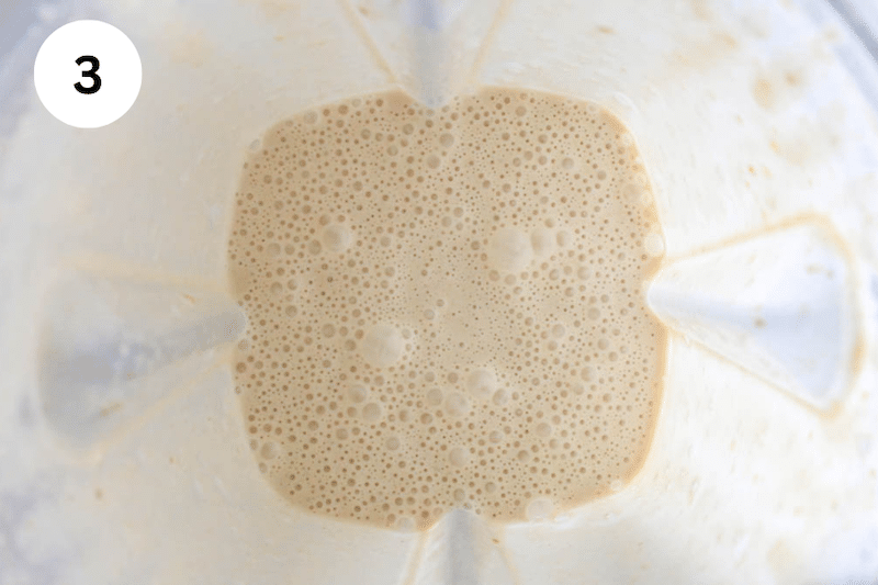 Inside a blender filled with a creamy smoothie mixture.