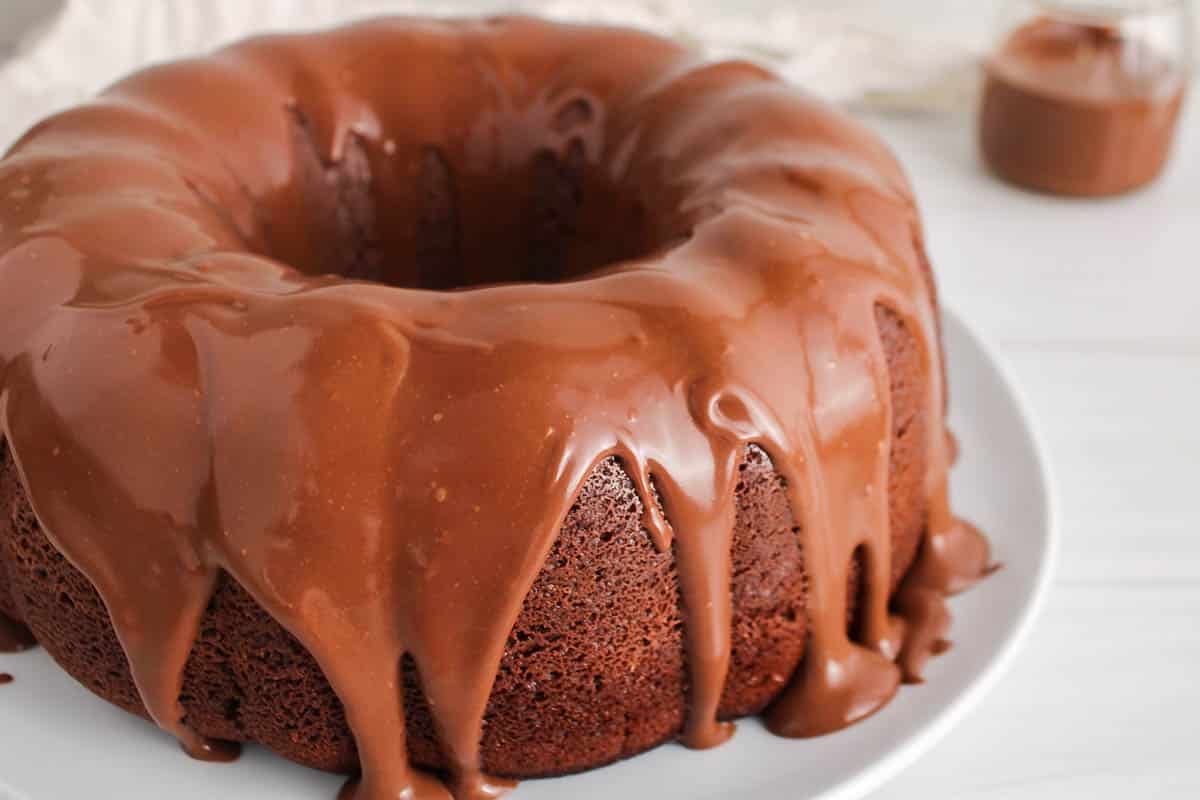 A vegan ganache falling off the sides of a vegan chocolate bundt cake.