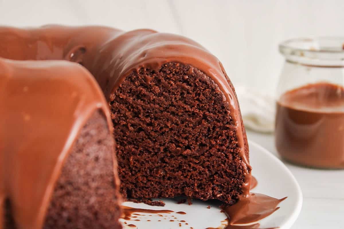 Vegan chocolate bundt cake with a piece taken off.Vegan chocolate bundt cake with a piece taken off.