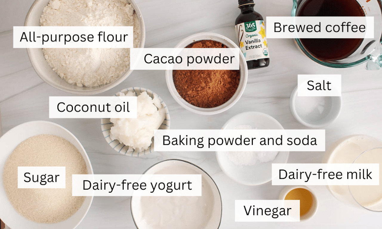 Ingredients needed to make a vegan chocolate bundt cake on a white table.