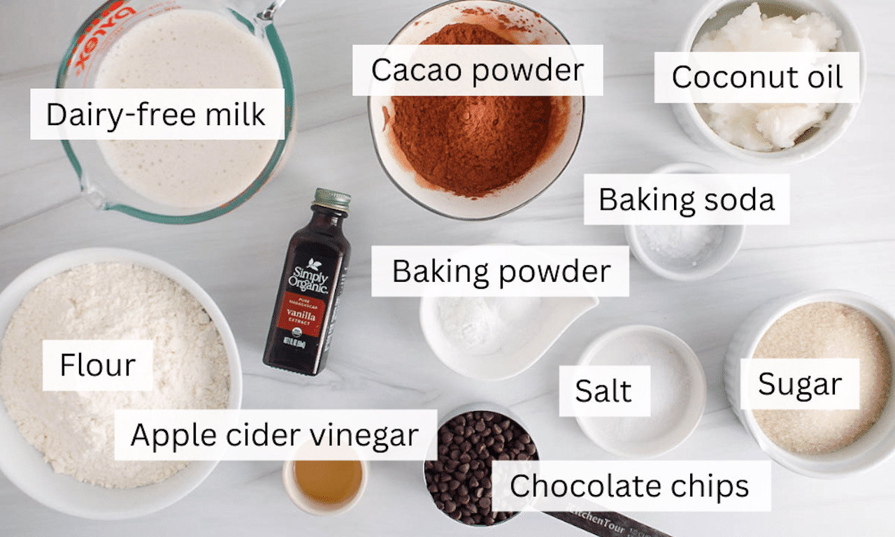 Ingredients needed to make a vegan chocolate loaf cake placed on a white counter.