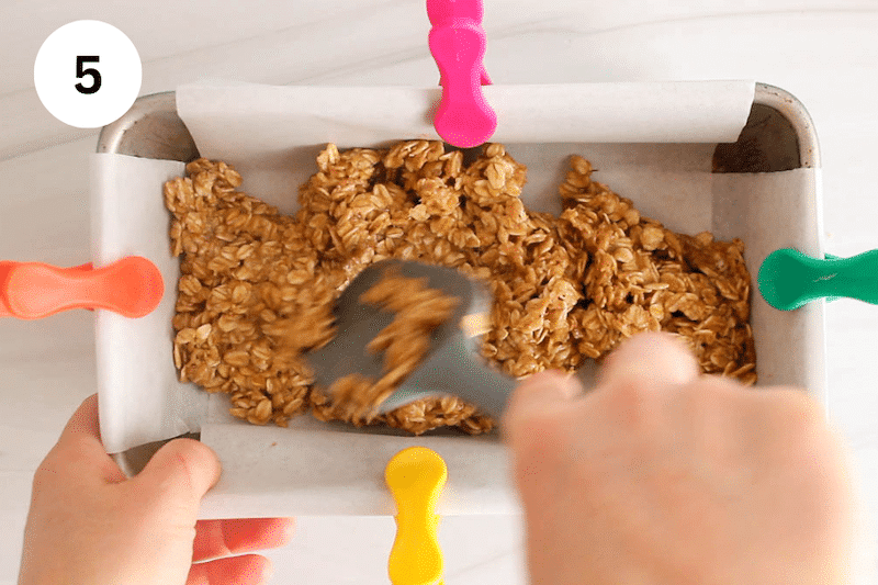 A spatula pressing to the bottom of a loaf pan.