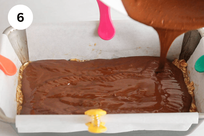 Chocolate sauce pouring over an oat mixture.