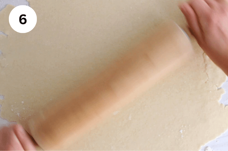 A rolling pin rolling a pie crust dough.