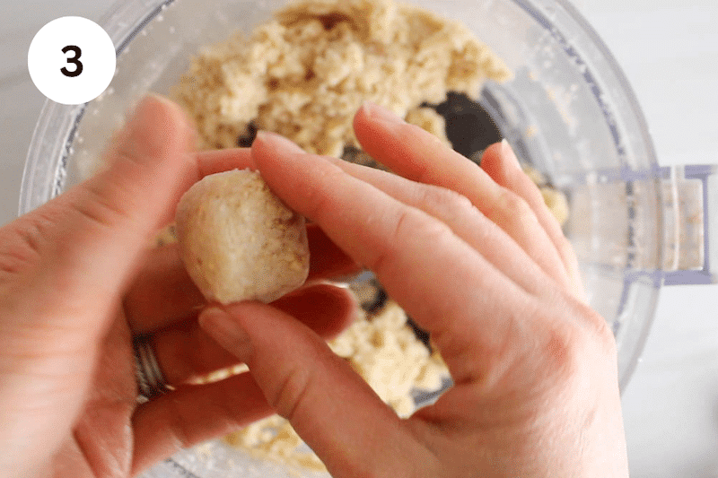 2 hands shaping a sticky lemon mixture into a balls.