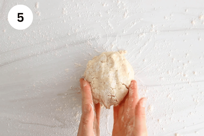 Hands shaping some dough into a ball.