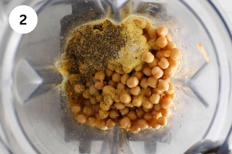 A blender with chickpeas and spices.