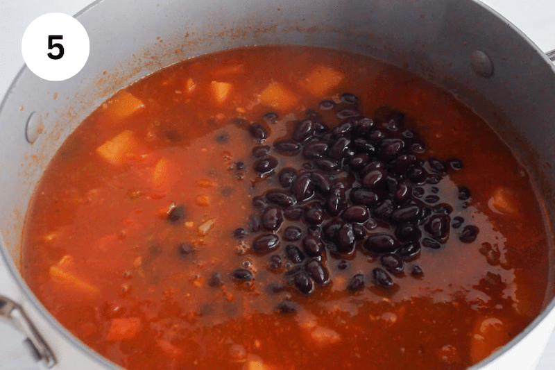 Black bean over a tomato broth in a large pot.