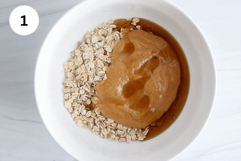 A bowl with oats, peanut butter and maple syrup.