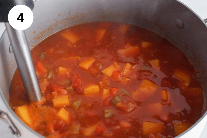 An immersion blender blending some of the soup right into the pot.