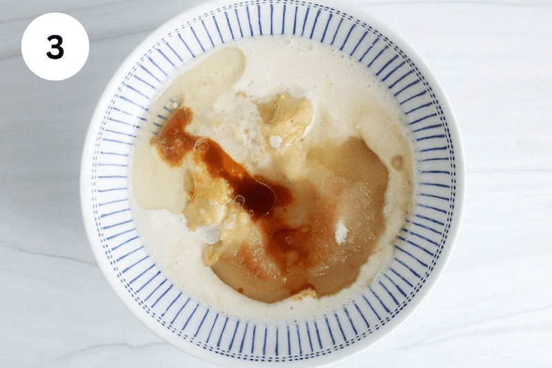 Mashed banana and other wet ingredients in a bowl.