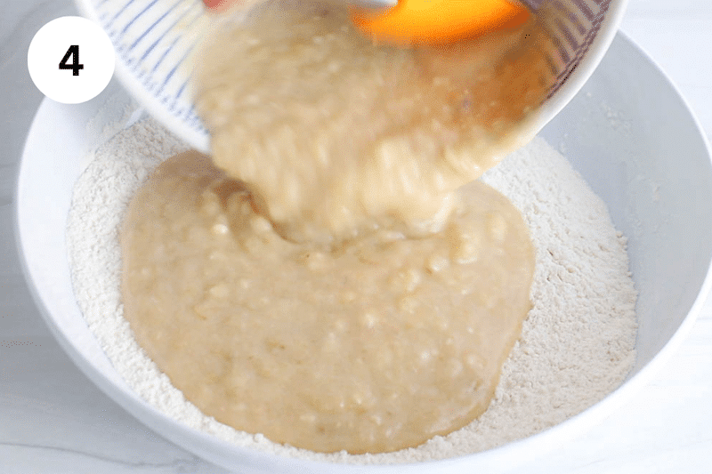 A wet mixture pouring over dry ingredients.