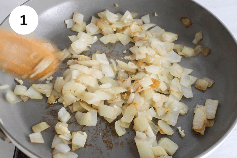 A pan cooking onion and garlic.