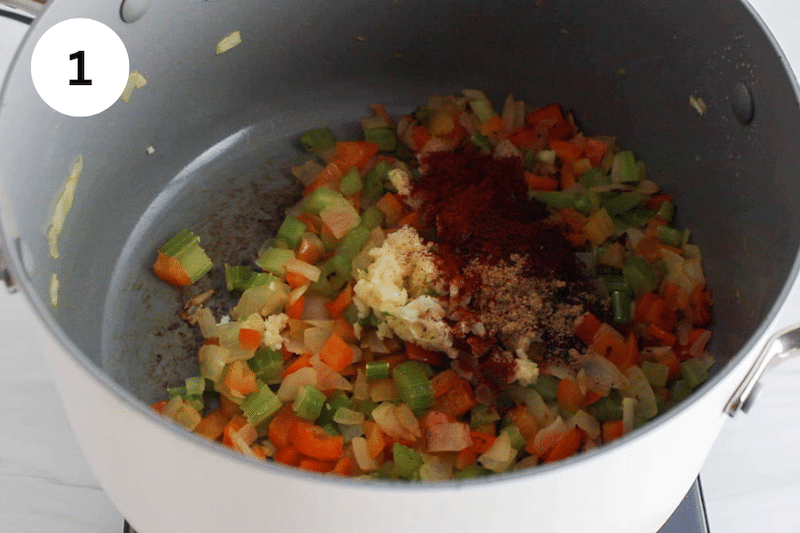 A large pot cooking onion with spices and garlic.