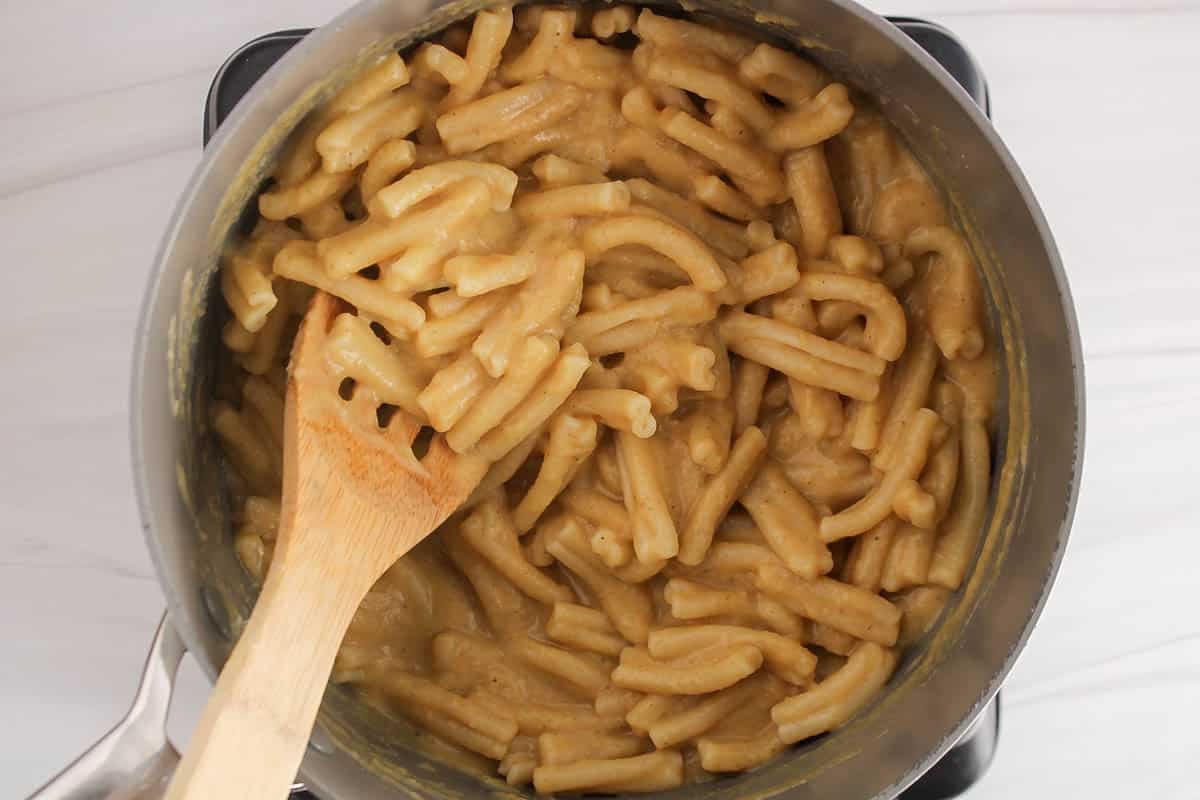 A large pot filled with a creamy pasta dish made with chickpeas.