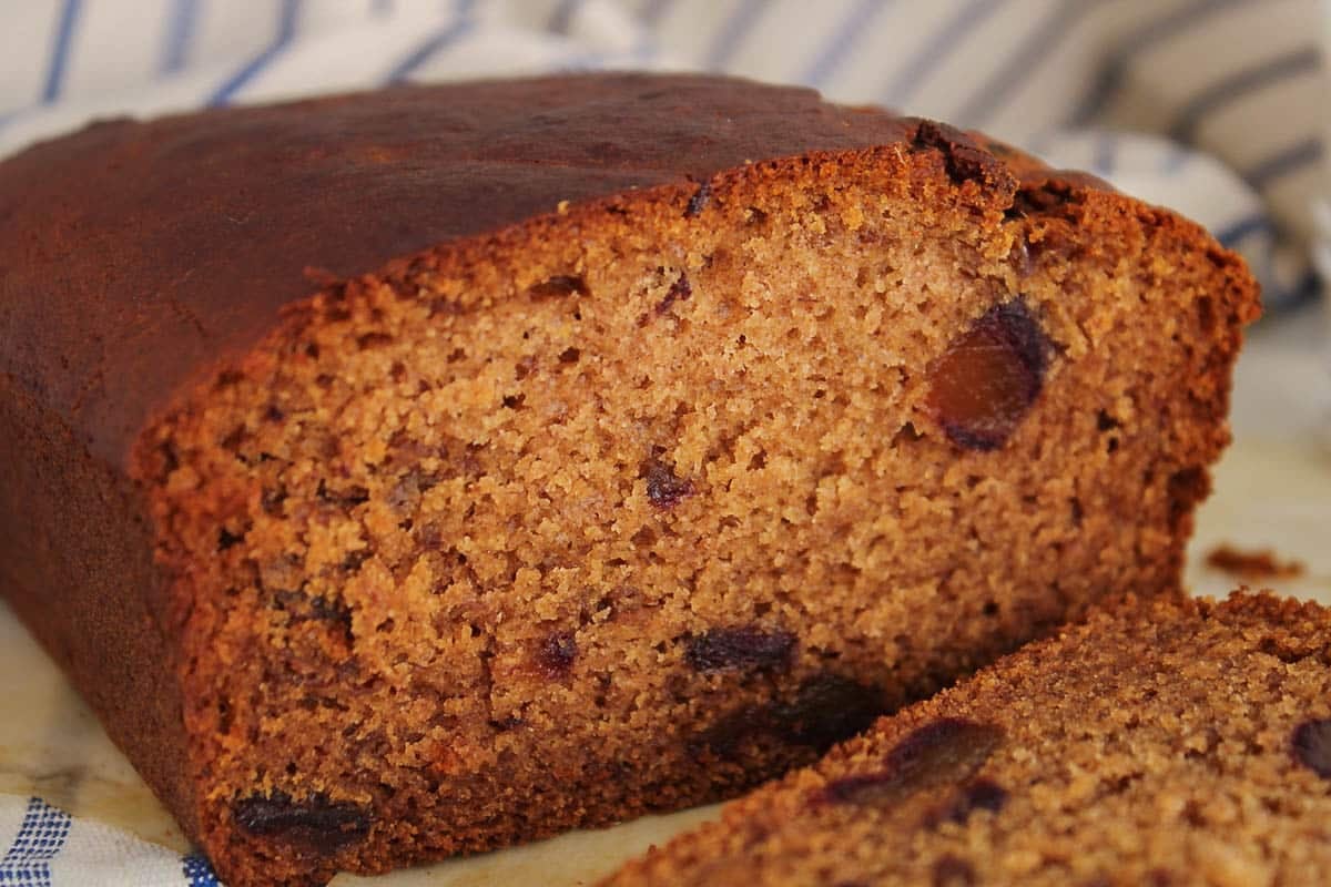 A half sliced vegan date cake.