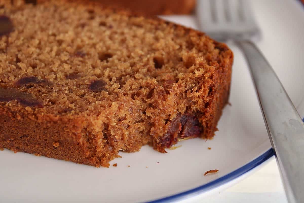 A slice of vegan date cake with a bite taken off.